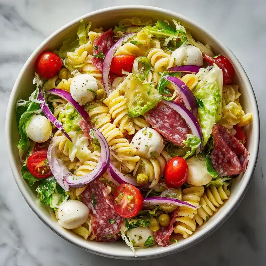 Grinder pasta salad in a white bowl with deli meats and mozzarella