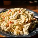 Creamy chicken pot pie pasta dish served in a bowl with herbs and spices