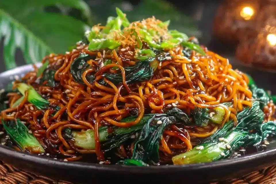 Sticky Garlic Chicken Noodles in a bowl garnished with fresh herbs and vegetables