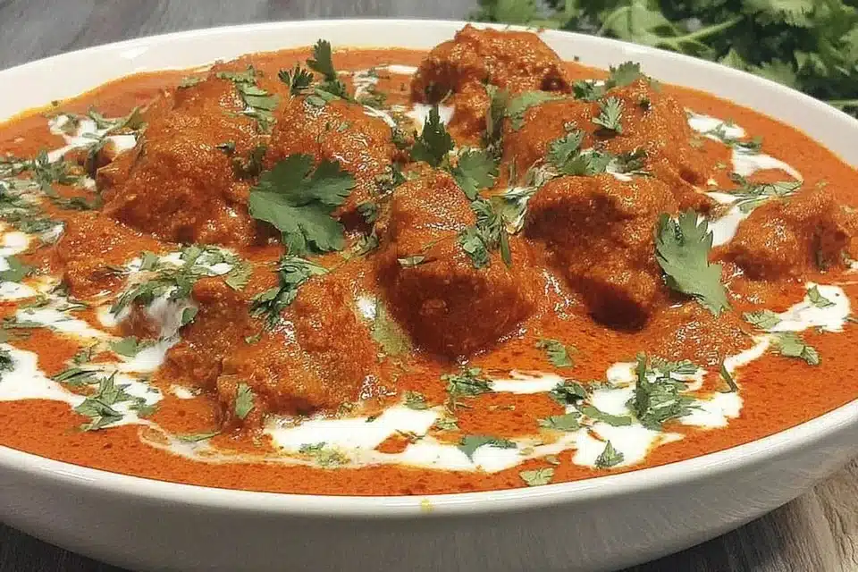 Delicious creamy butter chicken curry served with rice and naan