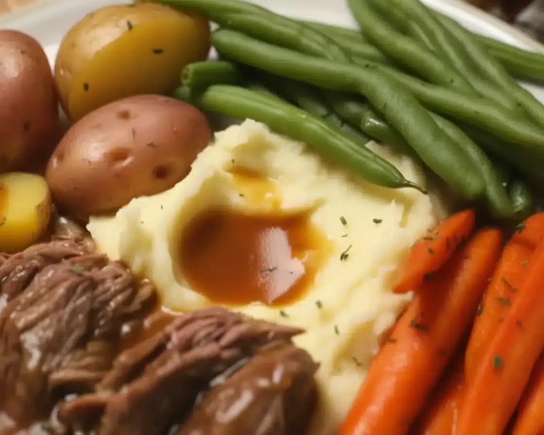 Cozy Slow Cooker Pot Roast with Gravy and Creamy Mashed Potatoes served on a plate.