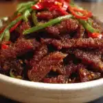 Crispy sweet chilli beef served with vibrant vegetables on a plate